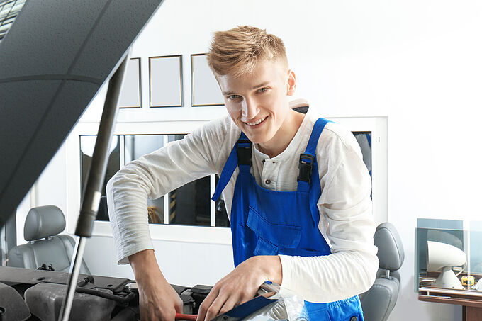 Kraftfahrzeug-Mechatroniker PKW (m/w/d) Young mechanic repairing car in body shop
